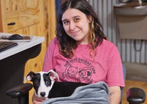 Woman holding black-white puppy